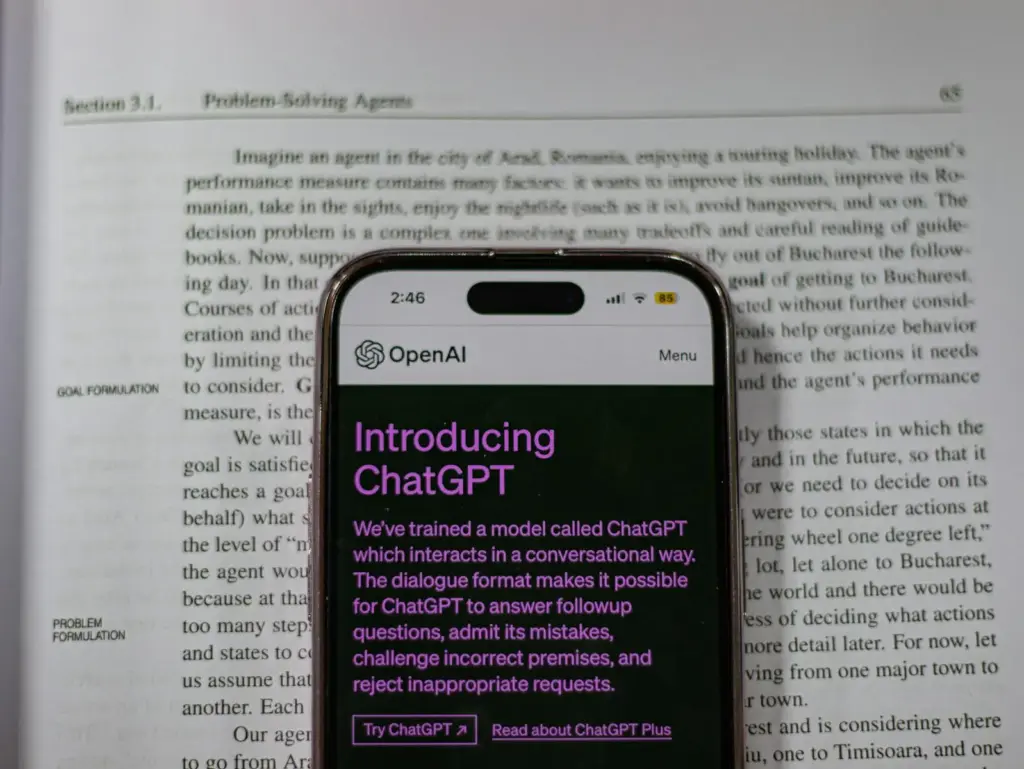 Smartphone showing OpenAI ChatGPT in focus, on top of an open book, highlighting technology and learning. Revolutionizing Content Creation: AI Trends to Watch Out For